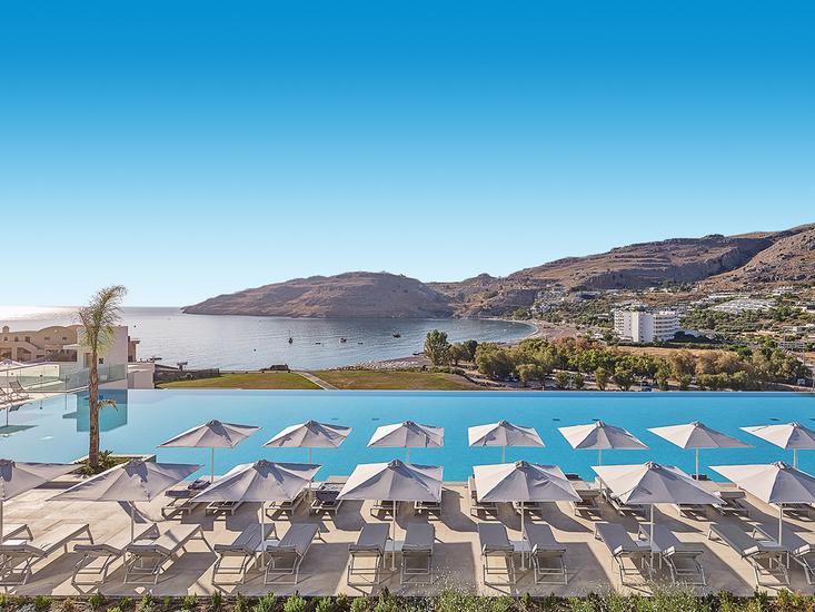zwembad met ligbedden en uitzicht van lindos grand resort en spa